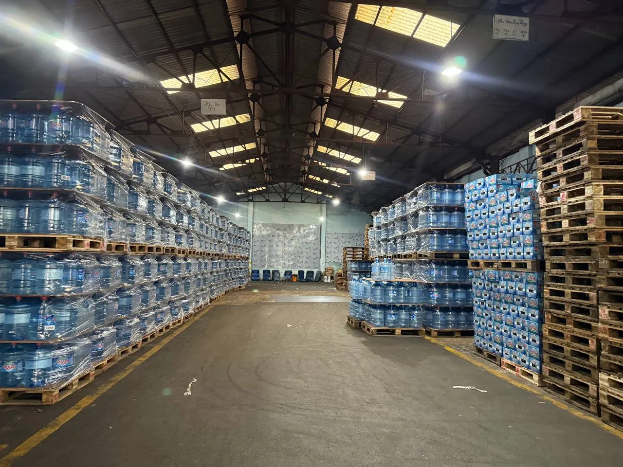 Lối đi trong kho Long Giang với các pallet nước xếp ngay ngắn theo hàng